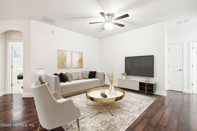 living room featuring a textured ceiling, ceiling fan, and dark hardwood / wood-style flooring