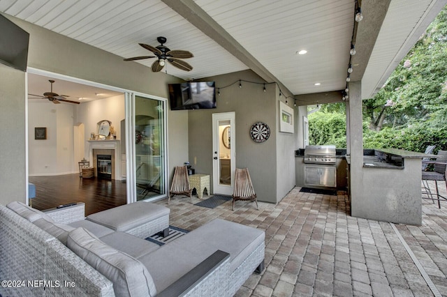 view of patio / terrace with an outdoor bar, ceiling fan, an outdoor living space, area for grilling, and an outdoor kitchen