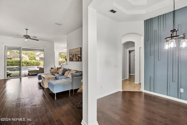 living room with ceiling fan and dark hardwood / wood-style flooring