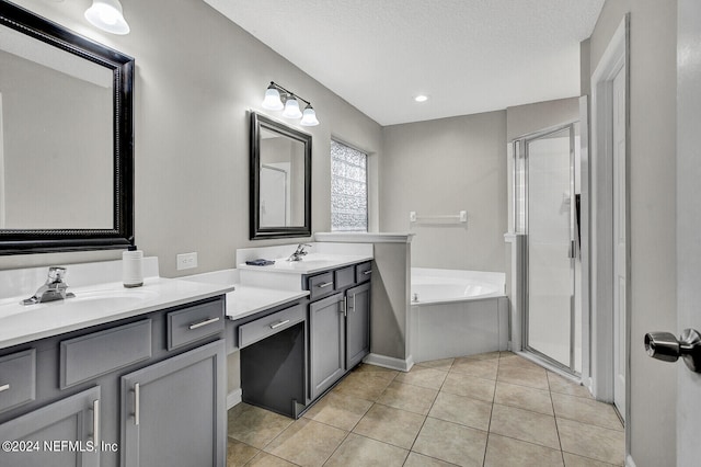 bathroom featuring tile patterned flooring, vanity, a textured ceiling, and separate shower and tub