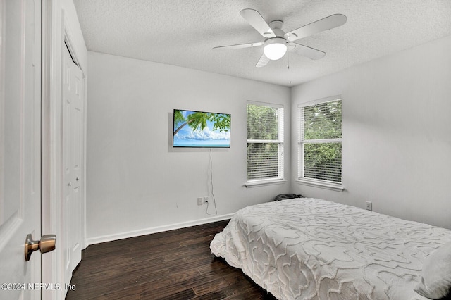 bedroom featuring dark hardwood / wood-style floors, a textured ceiling, ceiling fan, and a closet