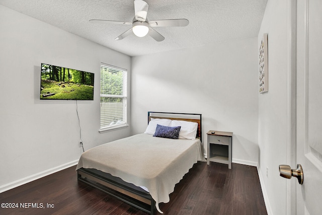 bedroom with dark wood-type flooring, ceiling fan, and a textured ceiling