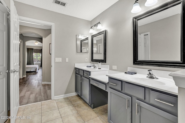 bathroom featuring tile patterned flooring, vanity, and a textured ceiling