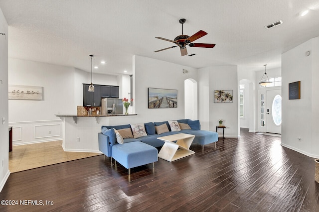 living room featuring dark hardwood / wood-style floors, a textured ceiling, and ceiling fan