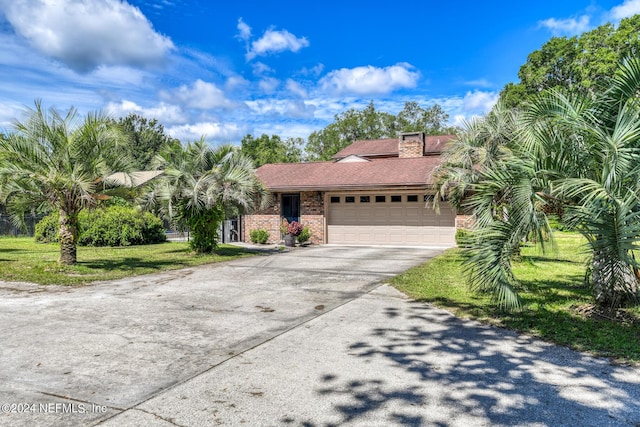 view of front of house featuring brick siding, a shingled roof, an attached garage, a front yard, and driveway