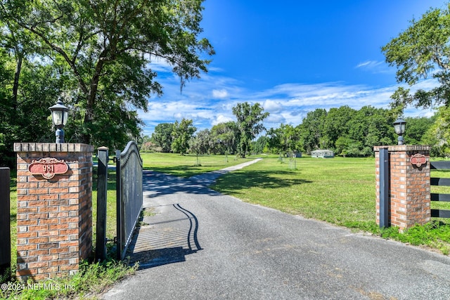 view of gate featuring a yard