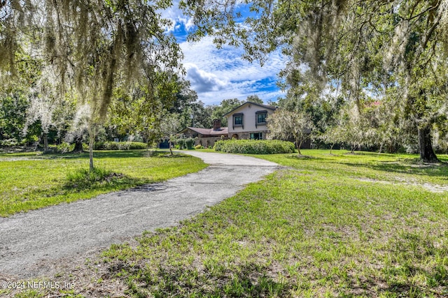 view of home's community featuring driveway and a yard