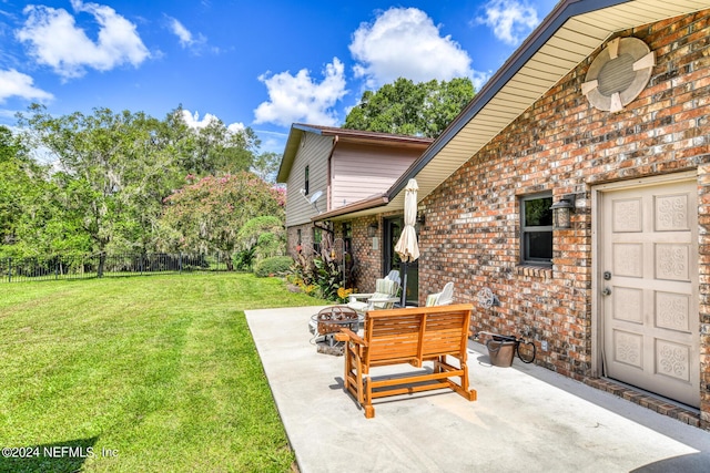 view of yard featuring a fire pit, fence, and a patio