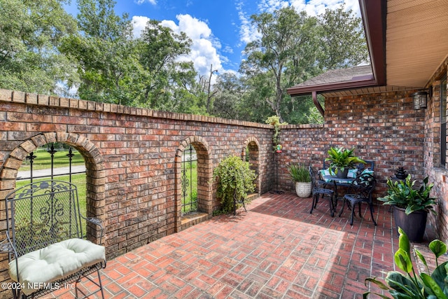 view of patio featuring outdoor dining space and fence