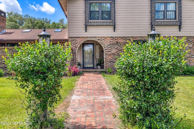 entrance to property featuring a lawn