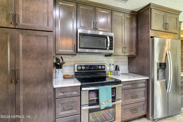 kitchen featuring stainless steel appliances, backsplash, and dark brown cabinetry