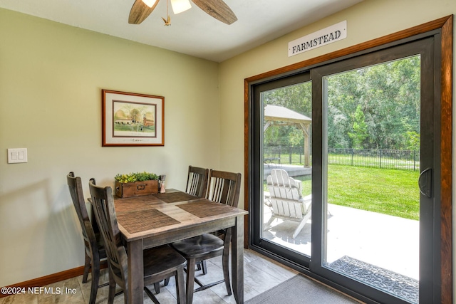 dining area featuring ceiling fan and baseboards