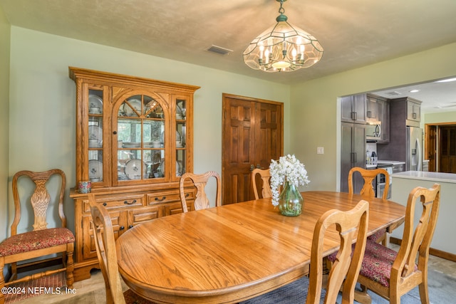 carpeted dining room with a chandelier