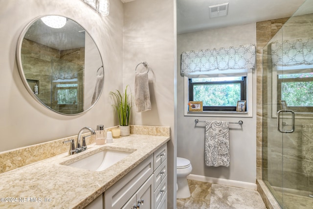 bathroom with tile patterned flooring, toilet, a wealth of natural light, and vanity