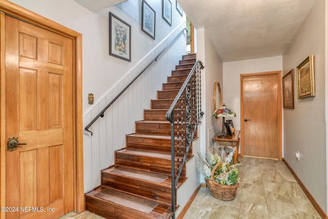 staircase with light tile patterned floors