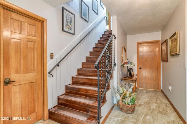 entryway featuring stairway and baseboards