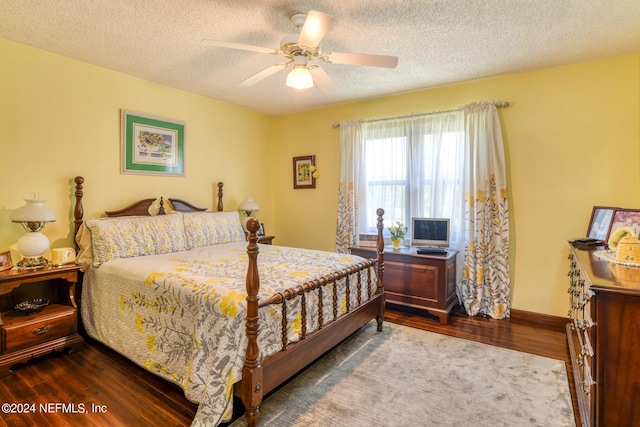 bedroom featuring a ceiling fan, a textured ceiling, baseboards, and wood finished floors