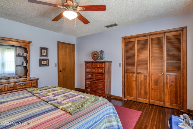 bedroom featuring a textured ceiling, ceiling fan, dark wood-style flooring, visible vents, and baseboards