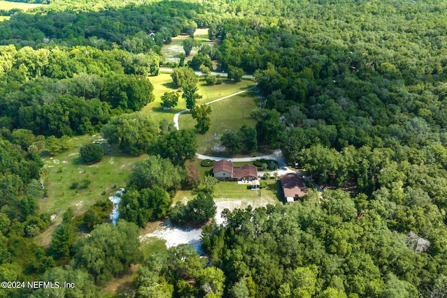 birds eye view of property featuring a forest view