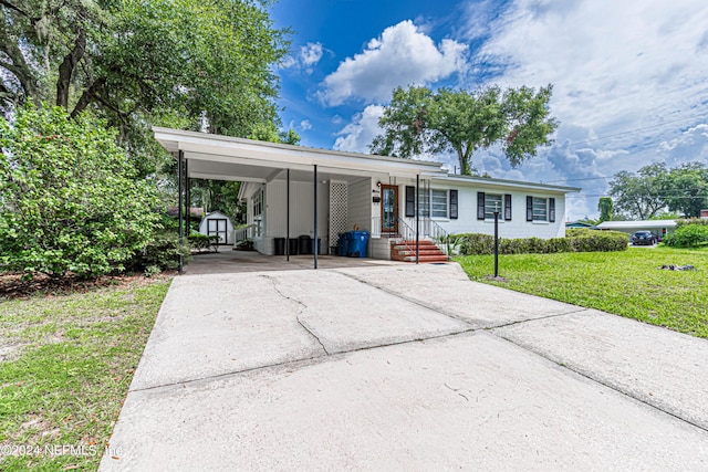 view of front of house featuring a front yard, a shed, and a carport