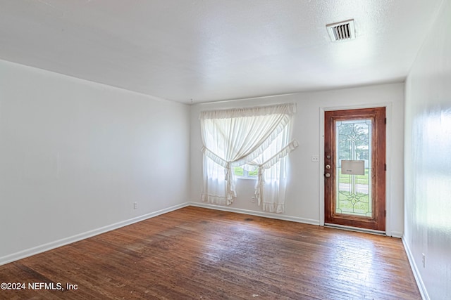 interior space featuring baseboards, visible vents, and wood finished floors