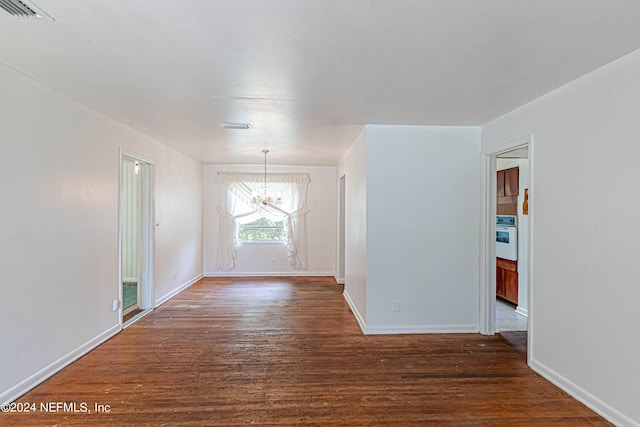 unfurnished room with a chandelier, visible vents, baseboards, and wood finished floors