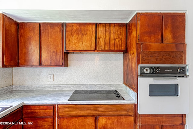 kitchen featuring white oven, light countertops, and black electric stovetop