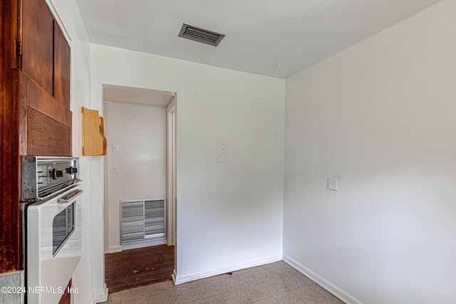 kitchen featuring white oven, visible vents, and baseboards