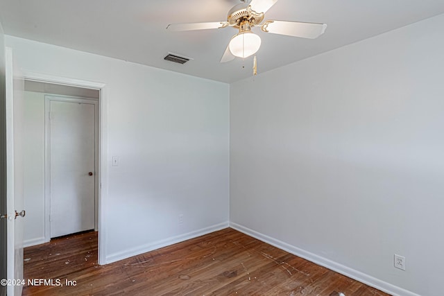 spare room featuring ceiling fan, wood finished floors, visible vents, and baseboards