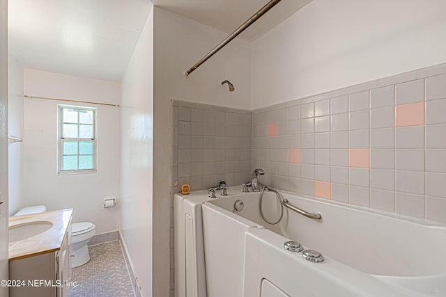 bathroom with toilet, vanity, a bathing tub, and tile patterned flooring