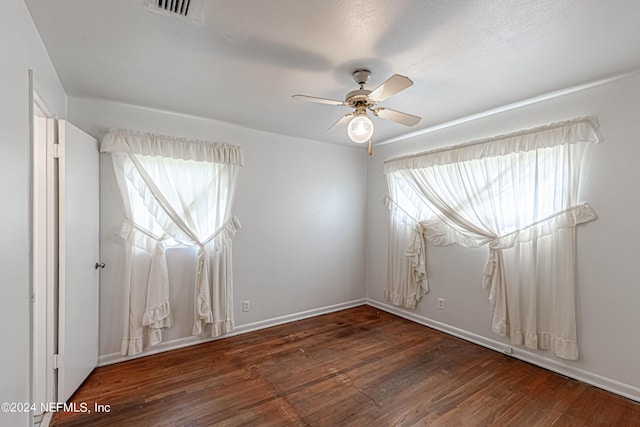 spare room featuring ceiling fan and dark hardwood / wood-style flooring