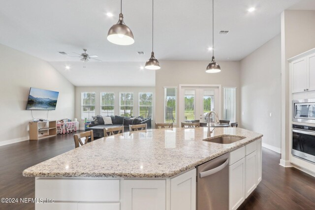 kitchen featuring sink, white cabinetry, hanging light fixtures, stainless steel appliances, and a kitchen island with sink