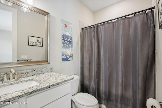 bathroom with vanity, toilet, and curtained shower