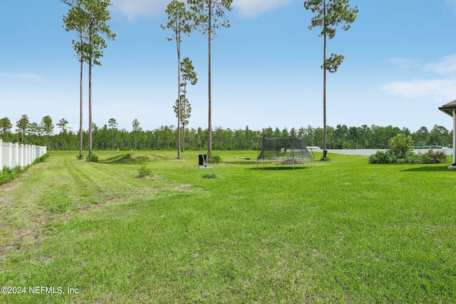 surrounding community featuring a trampoline, a lawn, and a water view