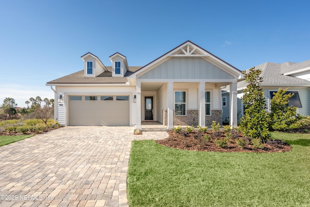 view of front facade featuring a garage, a porch, and a front lawn