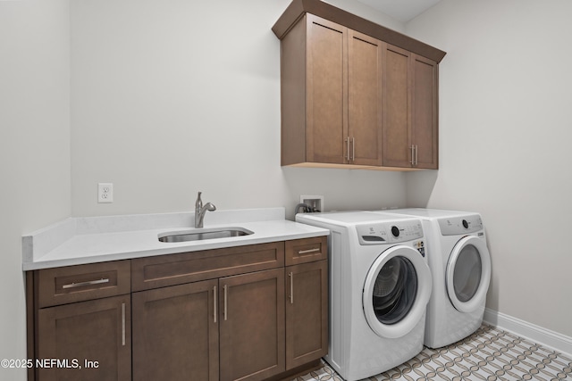 laundry area with cabinets, separate washer and dryer, sink, and light tile patterned floors