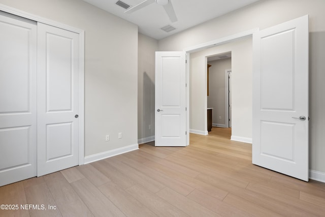 unfurnished bedroom featuring light hardwood / wood-style flooring, ceiling fan, and a closet