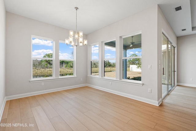 unfurnished room with a chandelier and light wood-type flooring