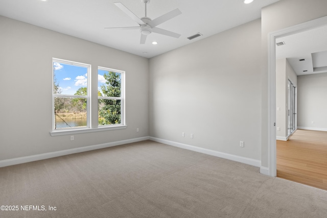 spare room featuring light carpet and ceiling fan