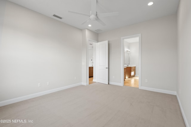 unfurnished bedroom with light colored carpet, ceiling fan, and ensuite bath