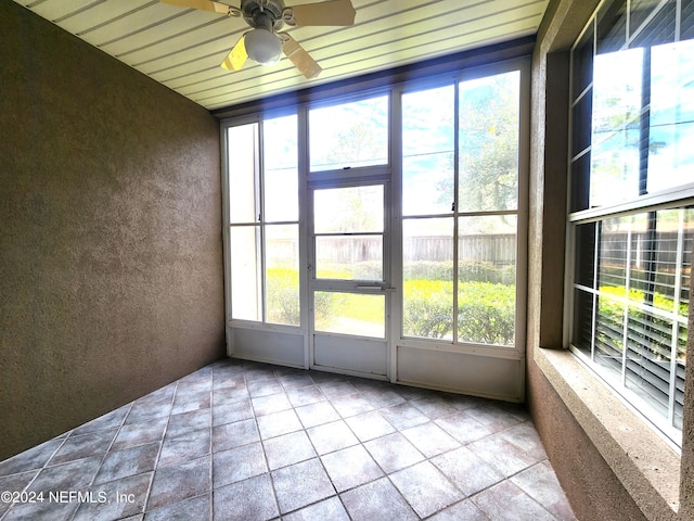 unfurnished sunroom with ceiling fan