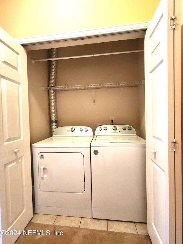 clothes washing area with light tile patterned floors and independent washer and dryer