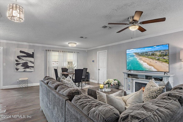 living room with ceiling fan, ornamental molding, dark hardwood / wood-style floors, and a textured ceiling