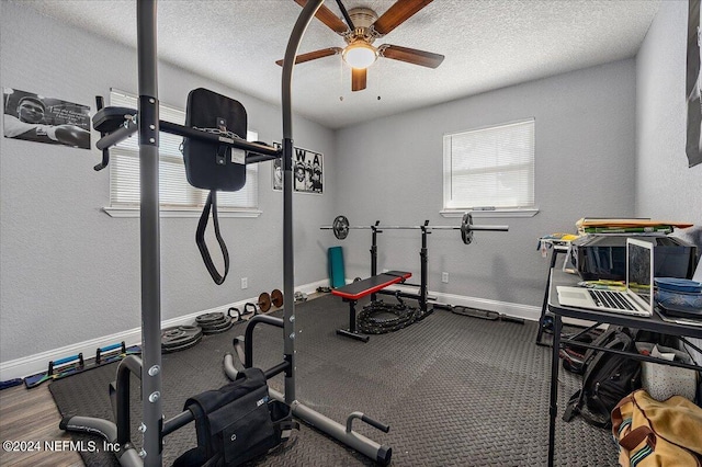 workout area featuring ceiling fan and a textured ceiling