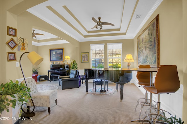 living room with carpet, ceiling fan, a raised ceiling, and crown molding