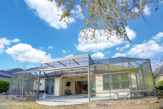 back of property featuring a lanai and a patio