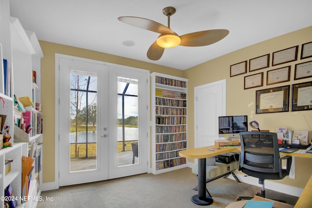 carpeted office space with a water view, french doors, ceiling fan, and a healthy amount of sunlight