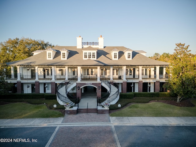 view of front facade featuring a balcony and a front lawn