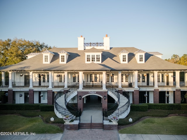 view of front facade featuring a balcony and a front yard