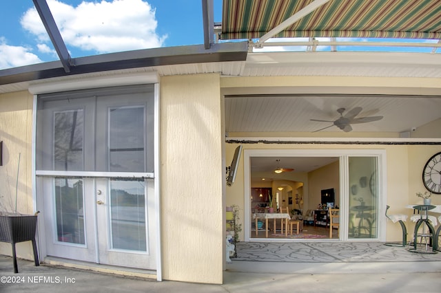 view of exterior entry with a patio area, ceiling fan, and french doors